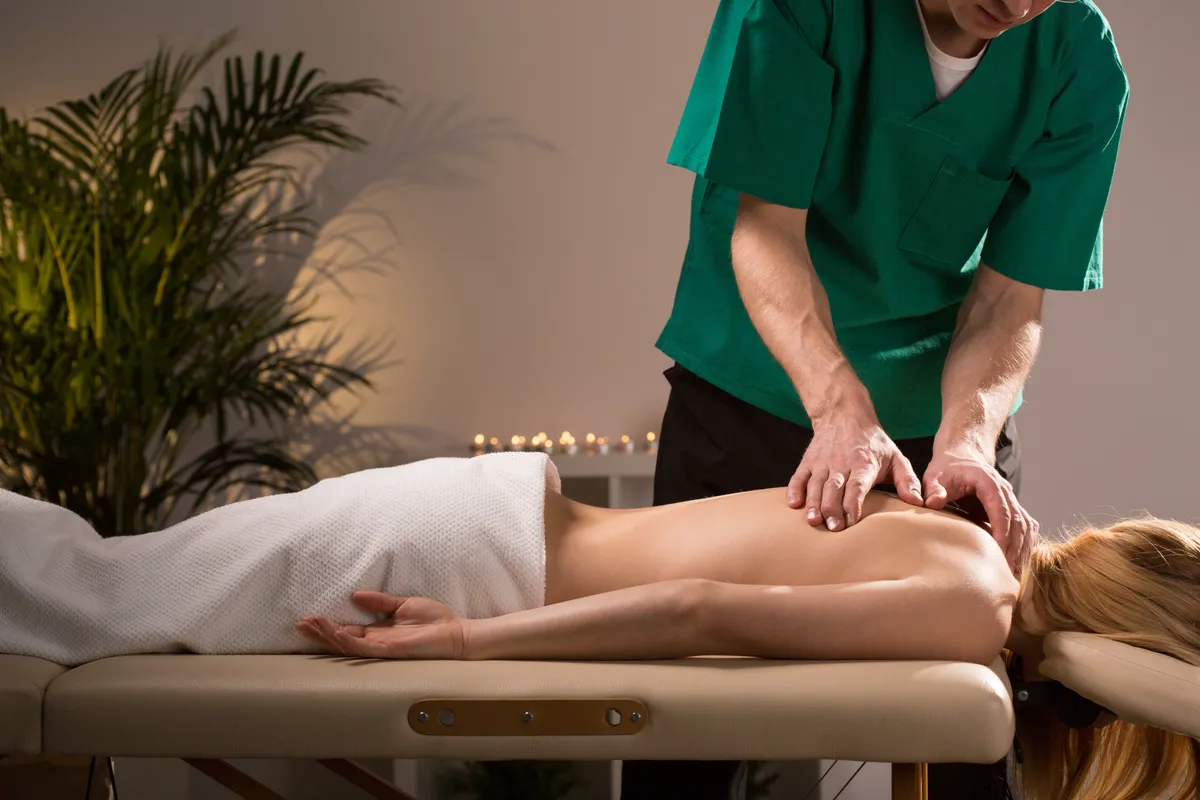 Chiropractor treating young woman in health center
