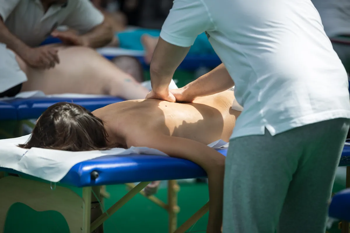 Athlete's Back Professional Massage on Bed after Sport Fitness Activity.