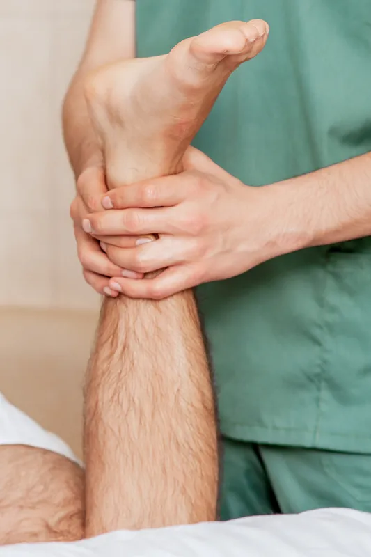Close up of foot of man in hand of massage therapist during health procedure.