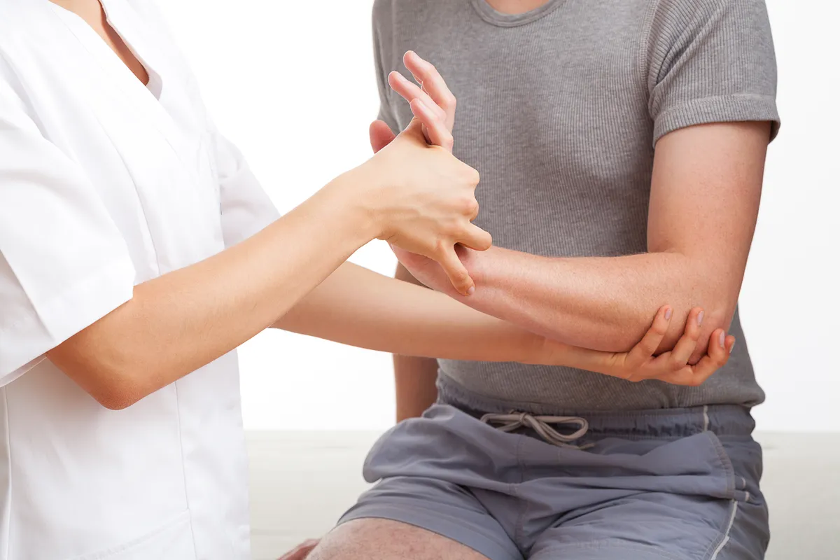 Female physiotherapist examining and massaging a hand