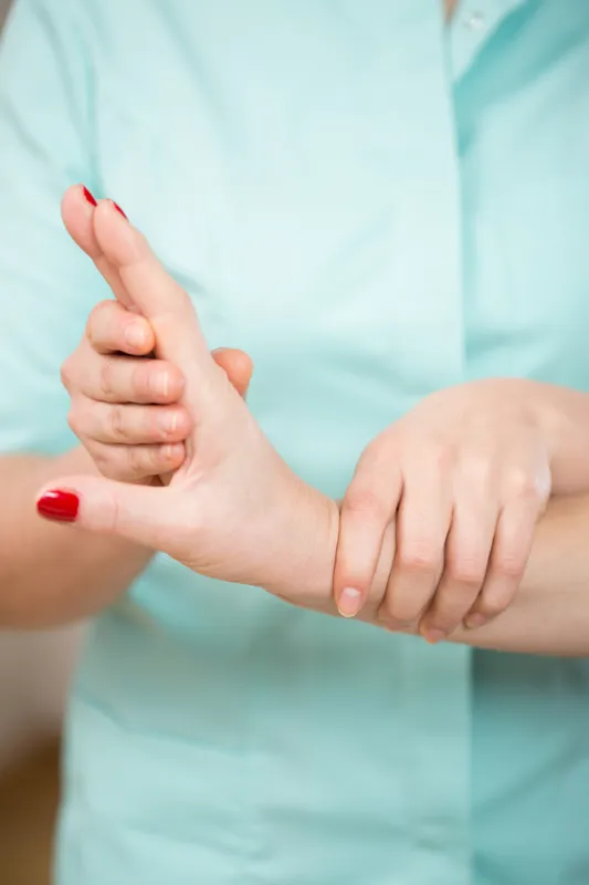 Close-up of physiotherapist's hands doing wrist exercise